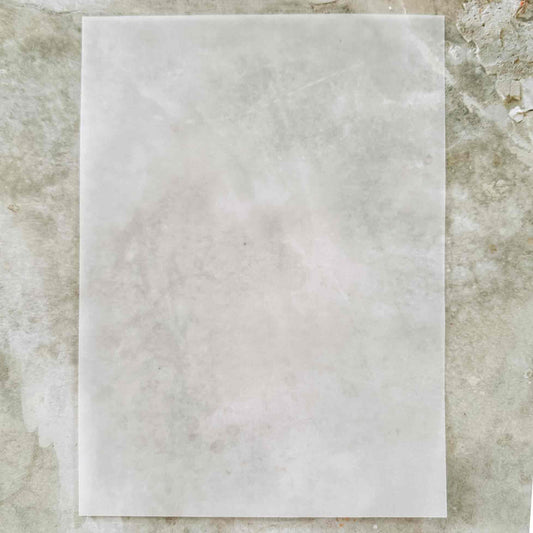 Square tile with a light gray marble pattern on a textured stone background
