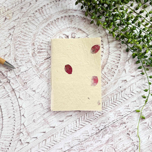 Compact A6 eco‑friendly Lokta notebook, embedded with deep pink Bougainvillea petals, hand‑stitched binding, tree‑free and ethically produced