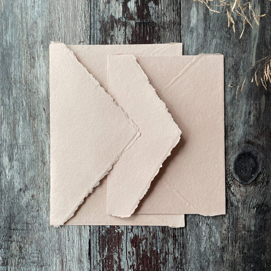 Invitation envelopes made from blush pink handmade paper. Deckle edge envelopes with a pointed flap. Handmade invitation envelopes made from recycled cotton rag fibres. By The Natural Paper Company