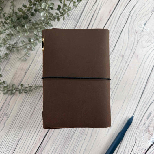 Brown A6 refillable leather notebook with simple black elastic closure