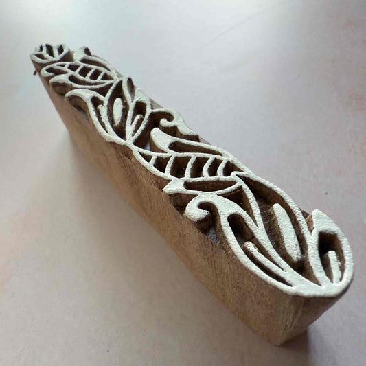 Wooden stamp with leaf pattern on a light background