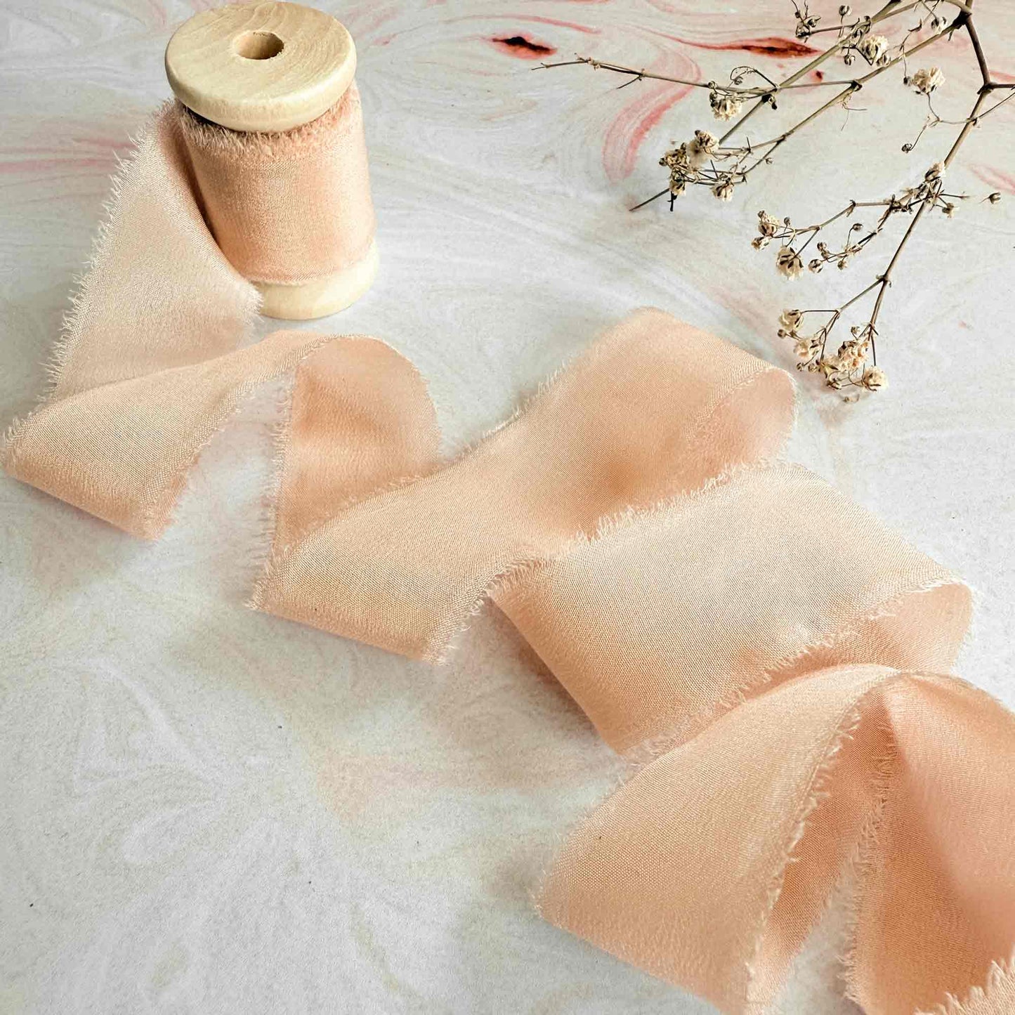 Peach colour silk ribbon with a frayed edge.  Perfect for wedding stationery and invitaitons