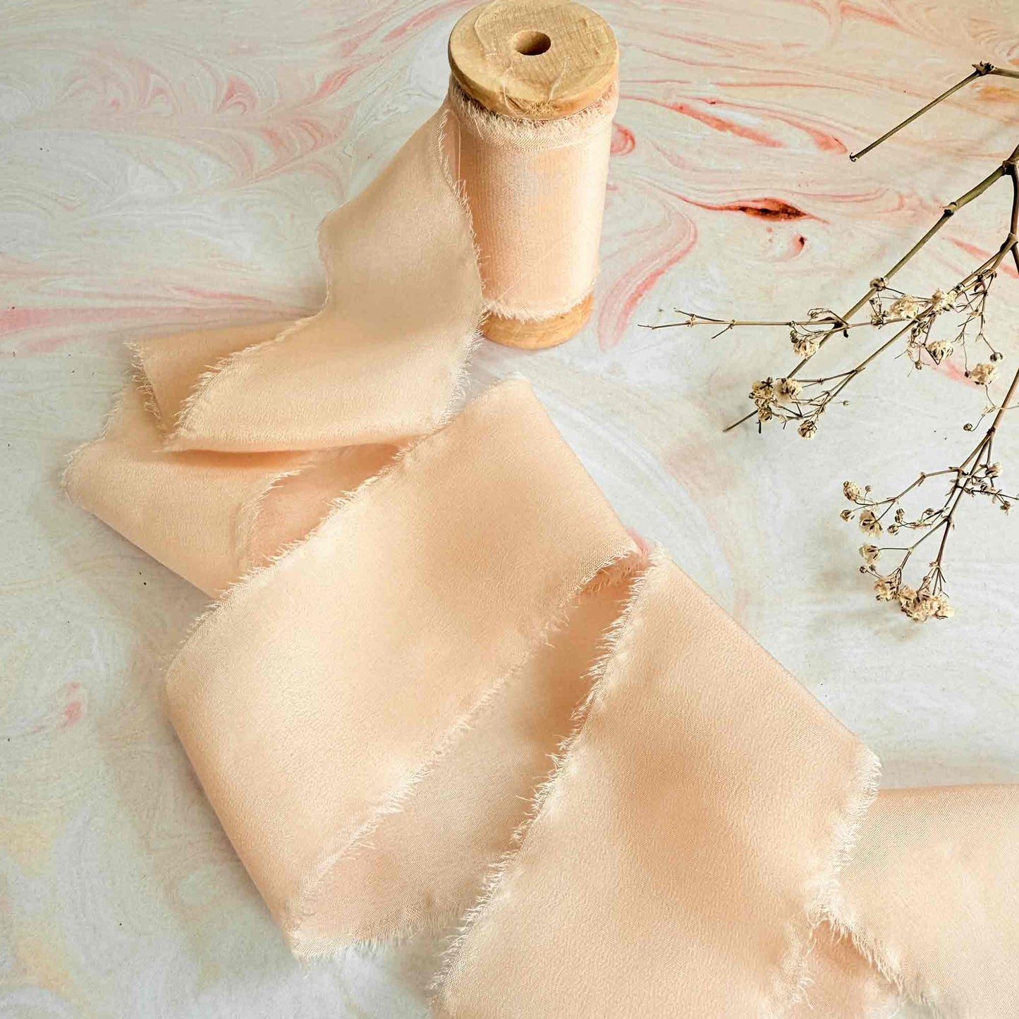 Peach Puff silk ribbon on a wooden reel.  Fine silk ribbon 50mm wide
