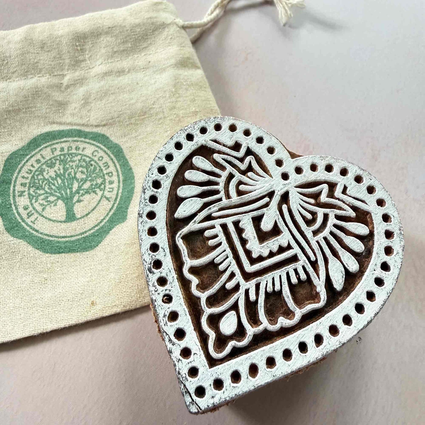 Heart-shaped wooden stamp with branded gift bag