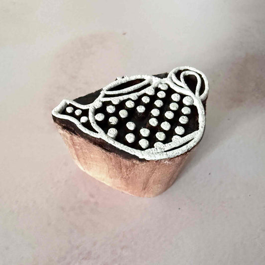 Wooden stamp with a tea pot design on a light background