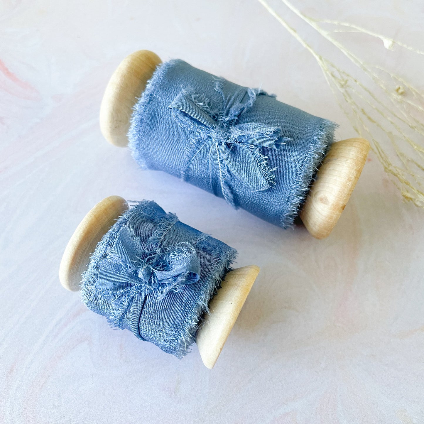 Luxury silk ribbon in airforce blue. Habota silk ribbon on a wooden reel. Available in narrow or wide lengths. Perfect to decorate wedding invitations, stationery, crafts and floristry. By The Natural Paper Company.