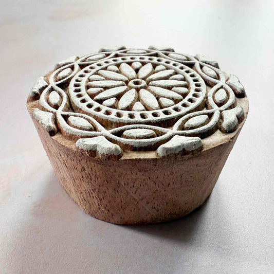 Wooden stamp with intricate carvings on a light background