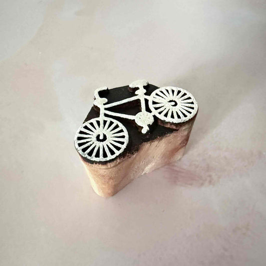 Wooden stamp with bicycle design on a light background