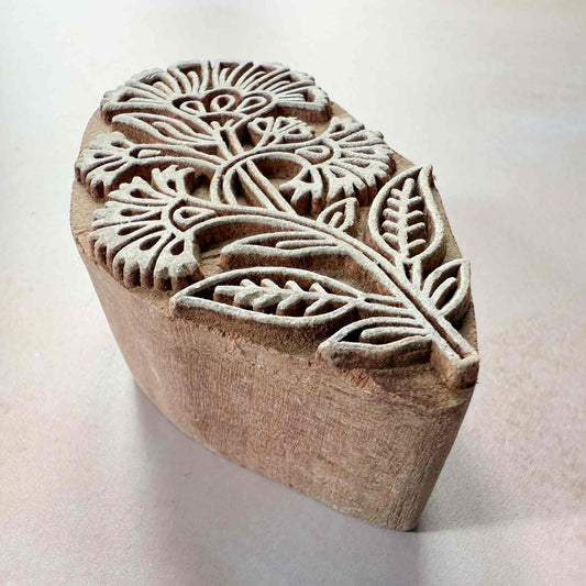 Wooden stamp block with floral patterns on a light background