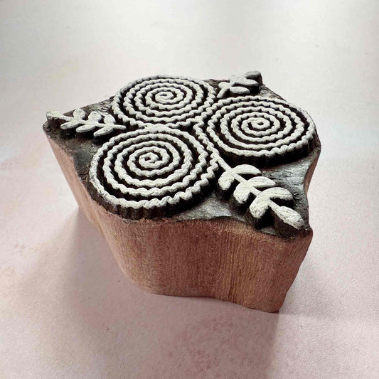 Wooden stamp with floral designs on a light background
