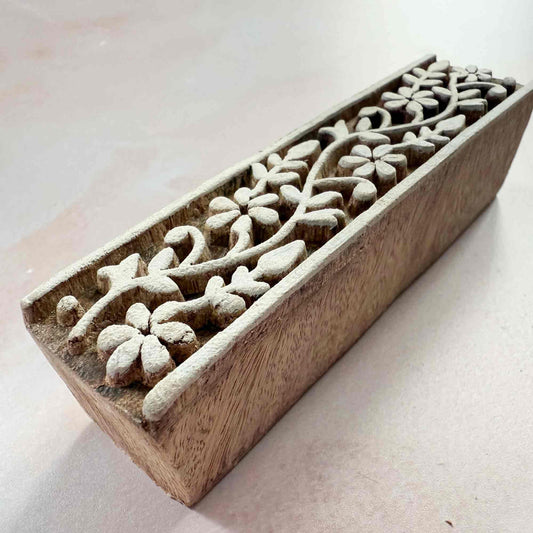 Wooden block with floral carvings on a light background