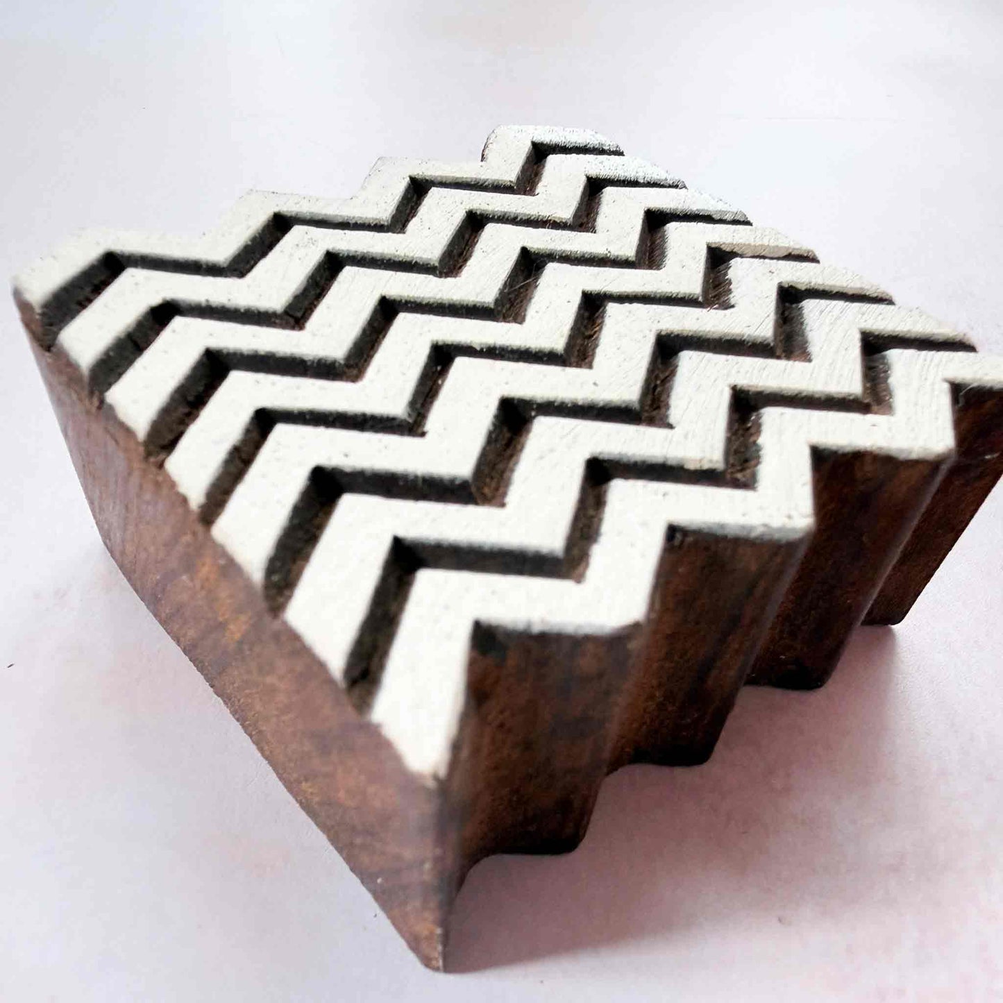 Hand-carved Chevron Indian wood block stamp — seven zigzag rows viewed from angle, showing carved depth and crisp chevron texture, square hardwood printing block from India