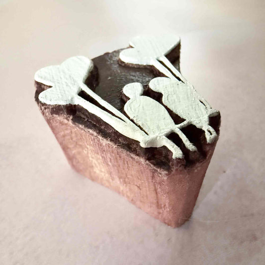 Wooden stamp with a couple holding heart shaped balloons