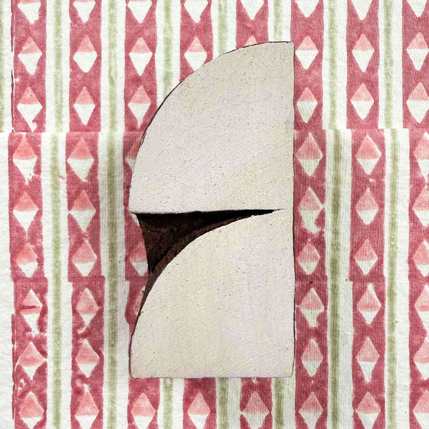Crescent wooden stamp — graceful curved arch resting on block printed fabric, handcrafted Indian printing block face-on view