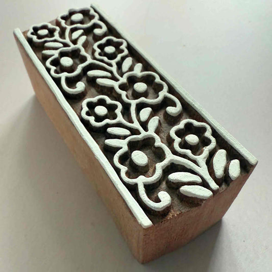 Wooden stamp block with floral patterns on a white background