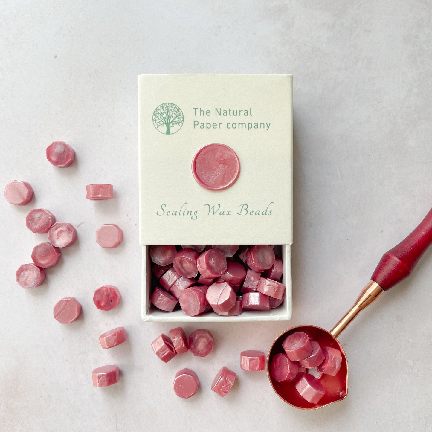 Box of sealing wax beads in pearlised dusky pink colour.  Eco friendly wax to make wax seals for invitations, envelopes and packaging.  By The Natural paper Company