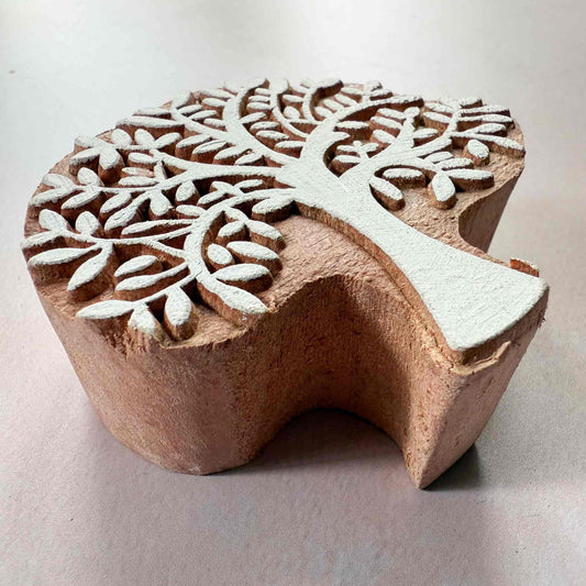 Wooden block with intricate tree design on a light background