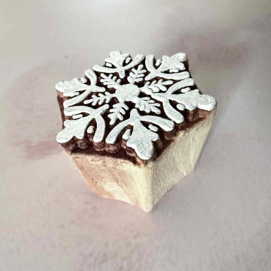 Square block with a snowflake design on a light background