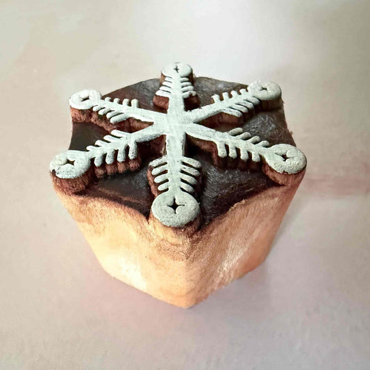 Wooden stamp with a snowflake design on a light background