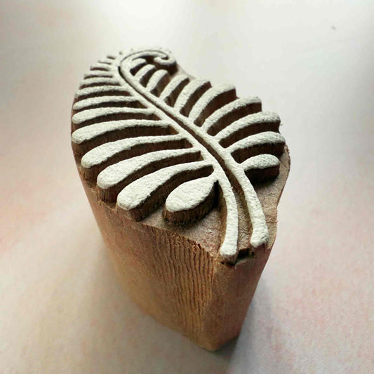 Wooden stamp with leaf design on a light background