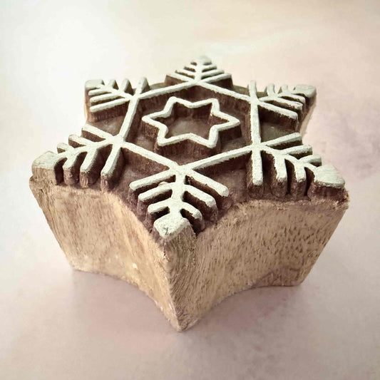 Wooden block with star and snowflake patterns on a light background