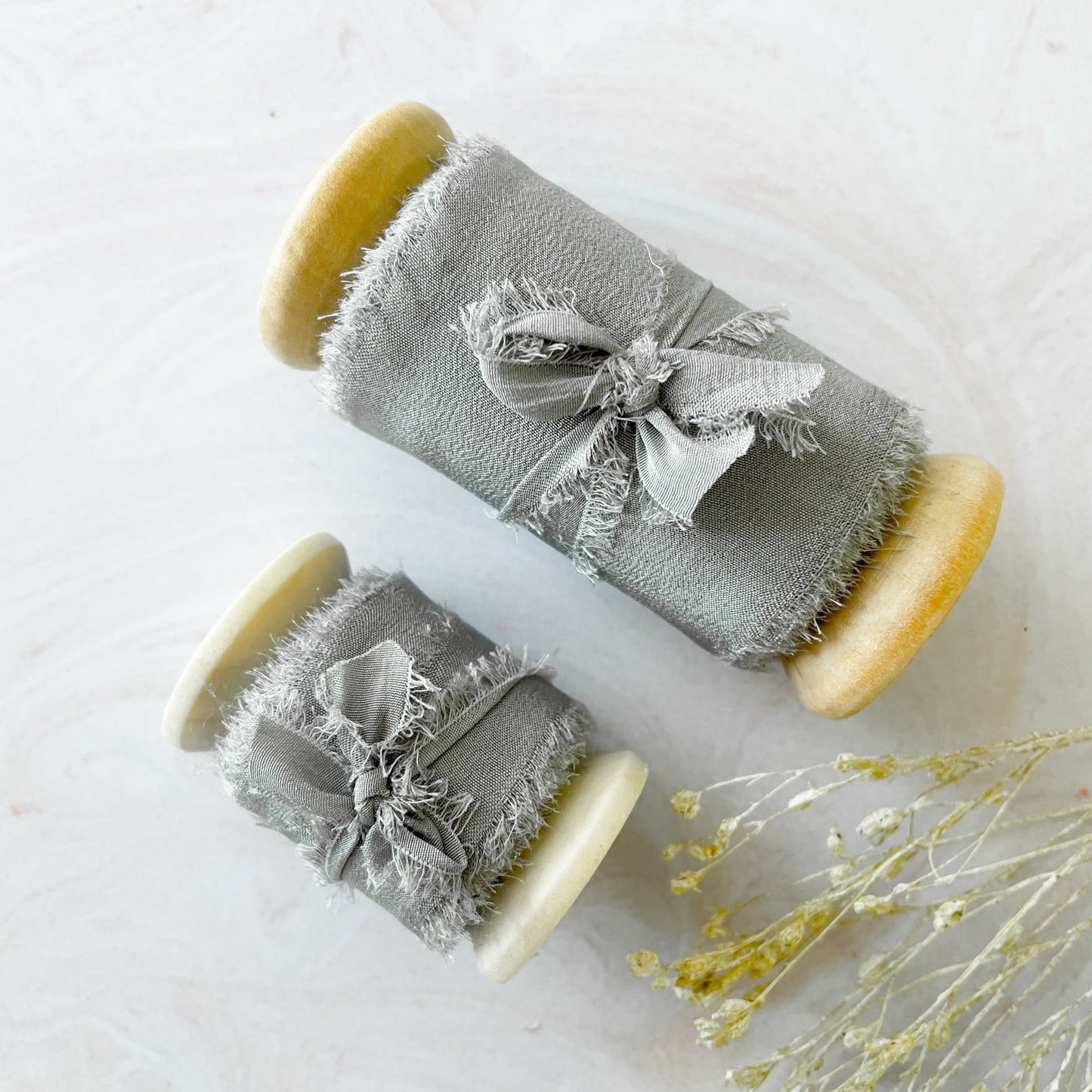 Silk ribbon for crafts. Light grey habotai silk ribbon sold on a wooden reel. Decorative silk ribbon for decorating wedding invitations, stationery and crafts. Available in 2 sizes. By The Natural Paper Company