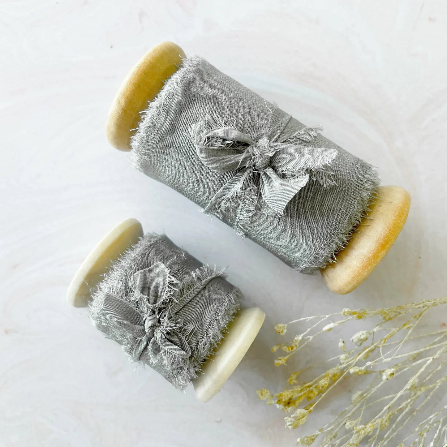 Silk ribbon for crafts. Light grey habotai silk ribbon sold on a wooden reel. Decorative silk ribbon for decorating wedding invitations, stationery and crafts. Available in 2 sizes. By The Natural Paper Company