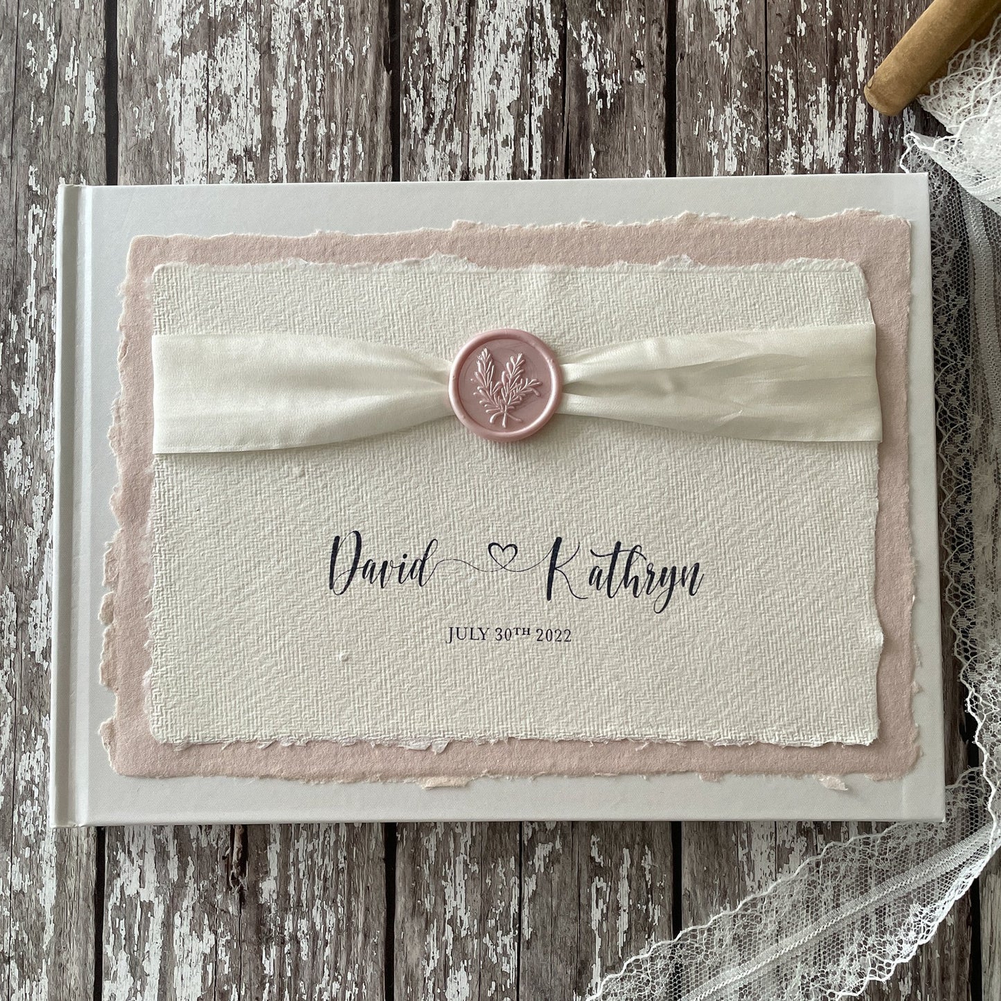 Personalised wedding guest book made from eco friendly materials By The Natural Paper Company.  Handmade paper guest book, recycled cotton rag paper and card; Silk Ribbon and a Wax seal in ivory and blush pink.