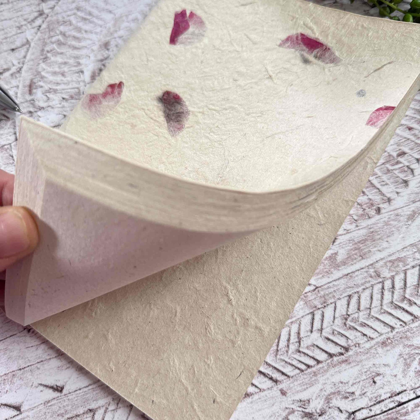 Close‑up of open Lokta notebook, displaying the soft, durable texture of acid‑free Lokta paper and the delicate Bougainvillea‑inlaid cover