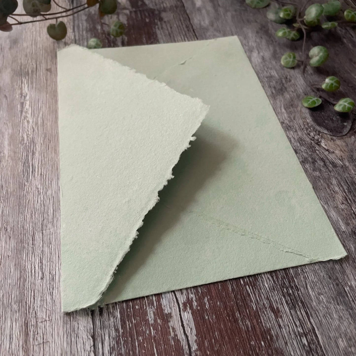 Invitation envelope made from dusky green handmade paper with a deckled edge pointed flap. Envelope made from recycled cotton rag paper in sage green. By The Natural paper Company
