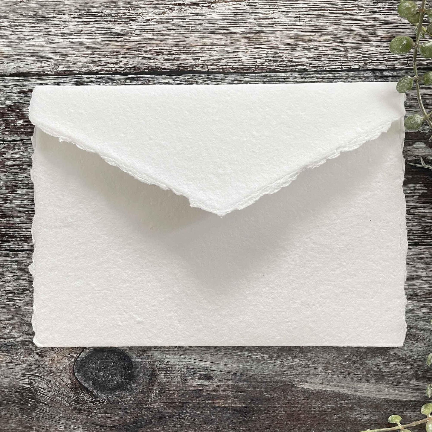 Blank pocket invitation made from handmade card in white. White handmade paper invitation with a deckled edge pointed flap and internal pocket for guest information .5 x 7 Handmade Card Pocket Invitation in Premium White. By The Natural Paper Company