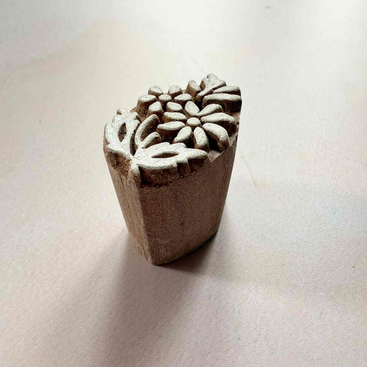 Wooden stamp with floral design on a light beige background
