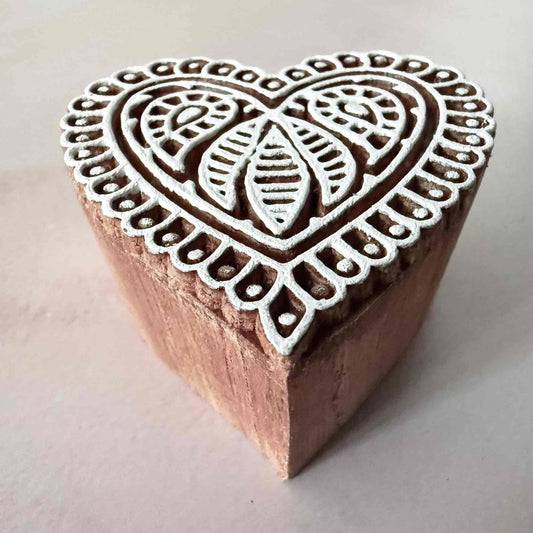 Wooden stamp with heart-shaped design on a light background