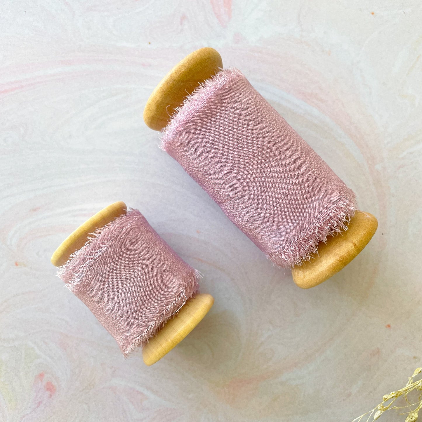 Lilac silk ribbon with frayed edges. Luxury silk ribbon on a wooden reel. Wide or narrow silk for decorating wedding invitations, stationery, floristry and crafts. By The Natural Paper Company.