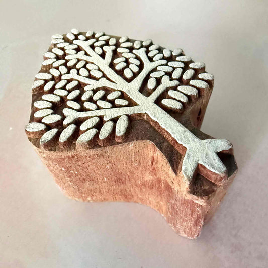 Wooden stamp with leaf pattern on a light background