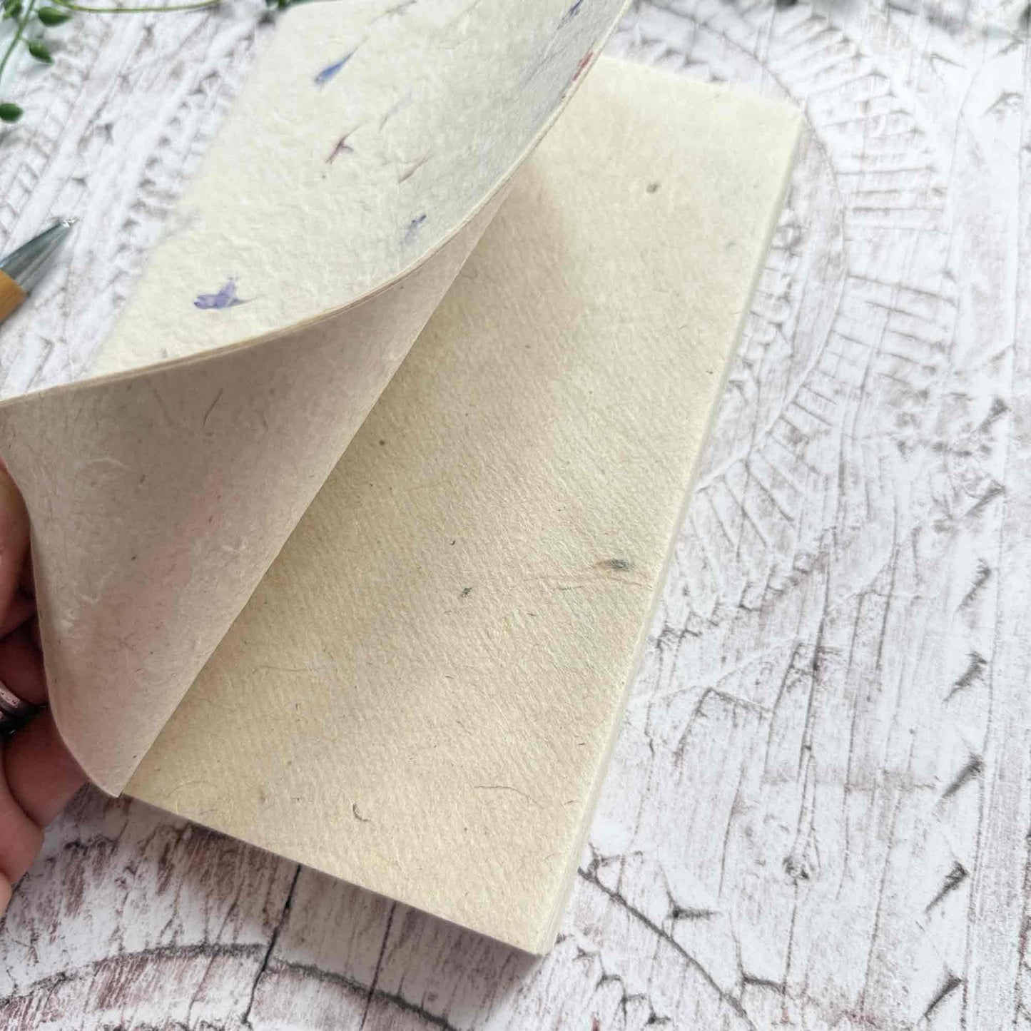 Close‑up of open Lokta notebook, displaying the soft, durable texture of acid‑free Lokta paper and the delicate Cornflower‑inlaid cover