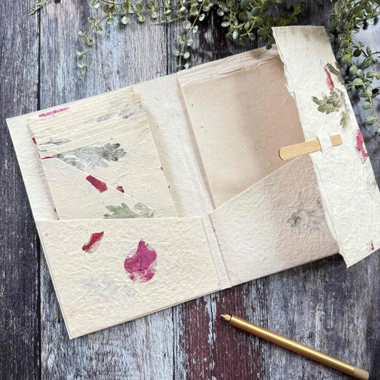 Handmade Lokta paper letter writing set open, showing folder, envelopes and paper sheets, botanical mugwort and bougainvillea details, bamboo closure, The Natural Paper Company