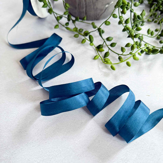 Blue ribbon and green plant on a white surface