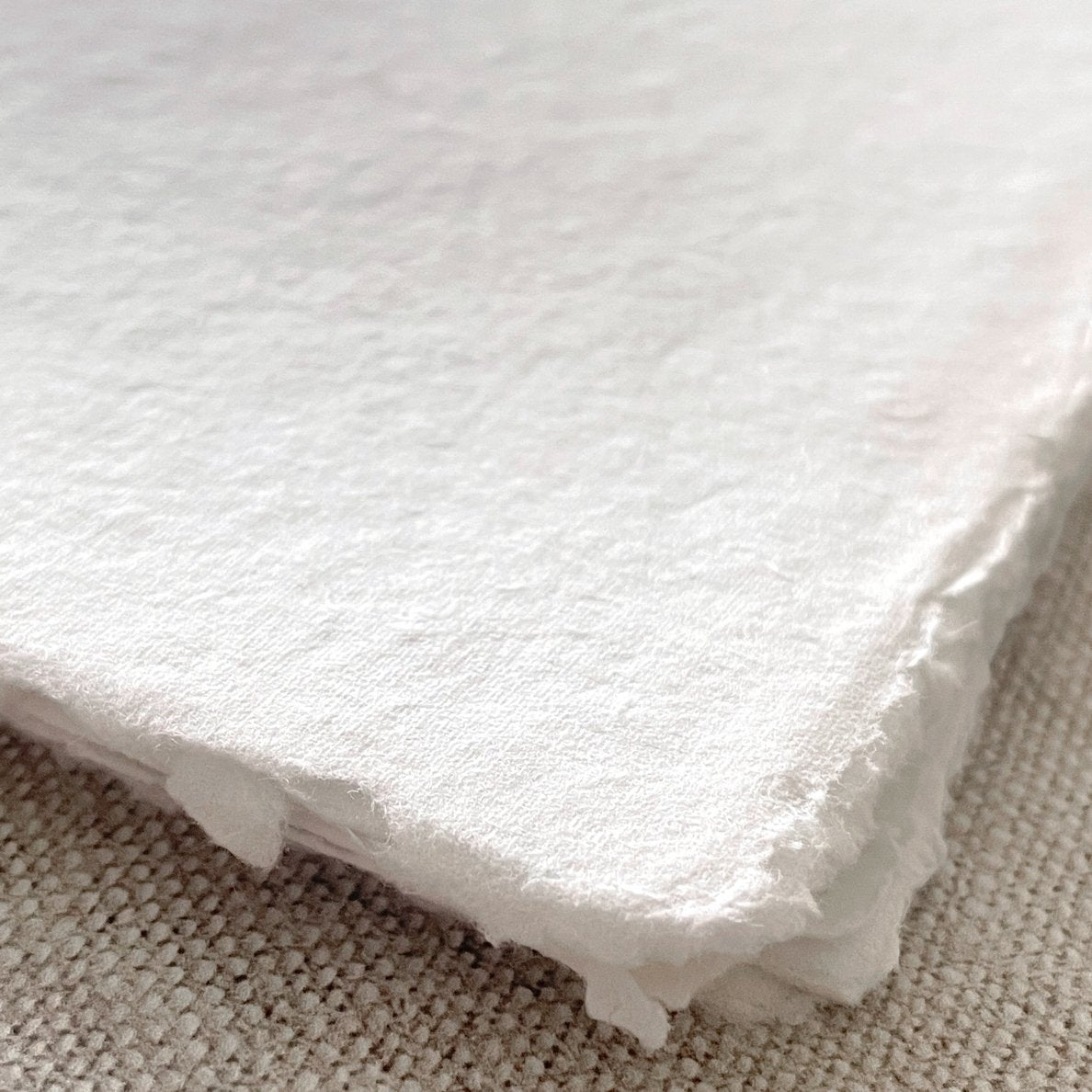 White handmade paper with a deckled edge. Recycled cotton rag paper. Vegan handmade paper for watercolour painting, crafts, calligraphy and invitations. By The Natural Paper Company