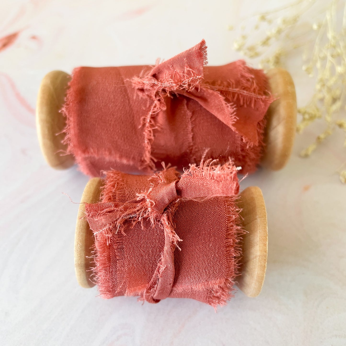 Rust colour silk ribbon on a wooden reel. Luxury silk ribbon for crafts and floristry. By The Natural Paper Company.