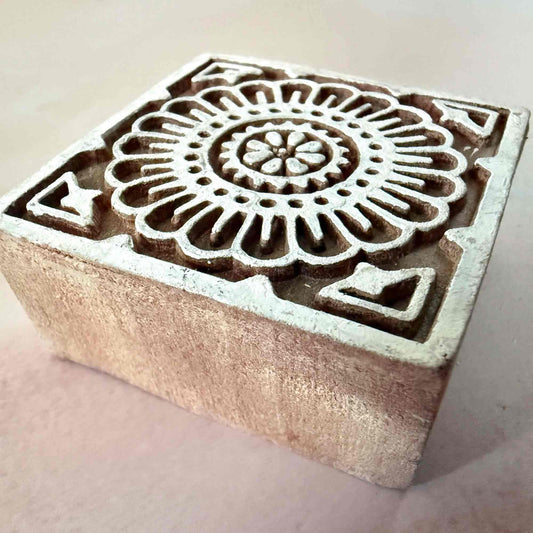 Square wooden stamp with floral design on a light background