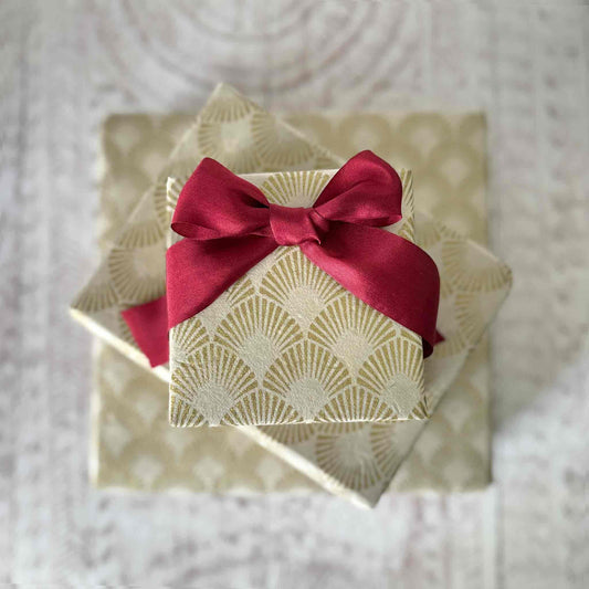 Handmade Lokta paper gift wrap wrapped boxes, gold pattern on cream paper with red silk ribbon