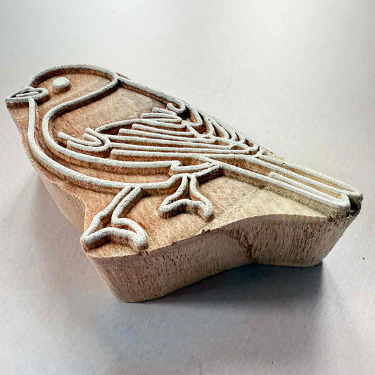 Wooden stamp with a fish design on a white background