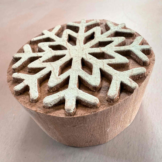 Wooden stamp with snowflake design on a light background