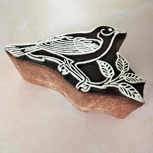Wooden printing block with bird design on a light background