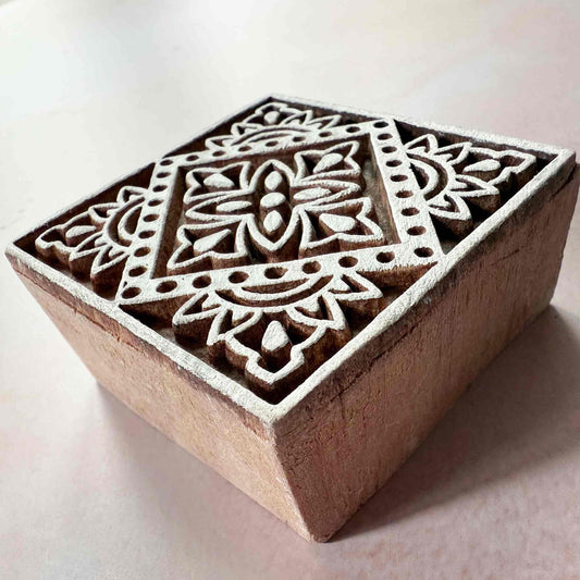 Wooden block with intricate geometric pattern on a light background