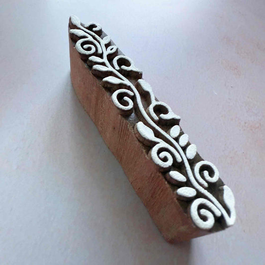 Wooden stamp with white floral design on a light background