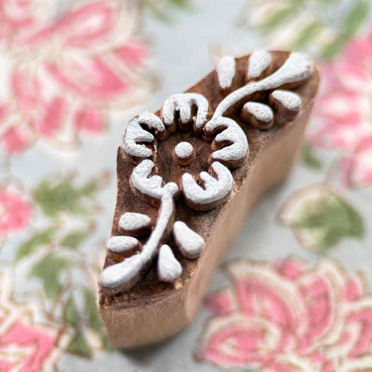 Decorative wooden stamp with floral design on a floral background
