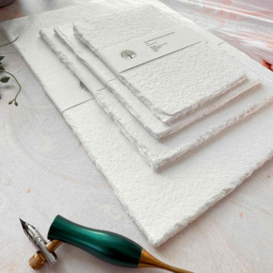 Set of white towels with a decorative tool on a light surface