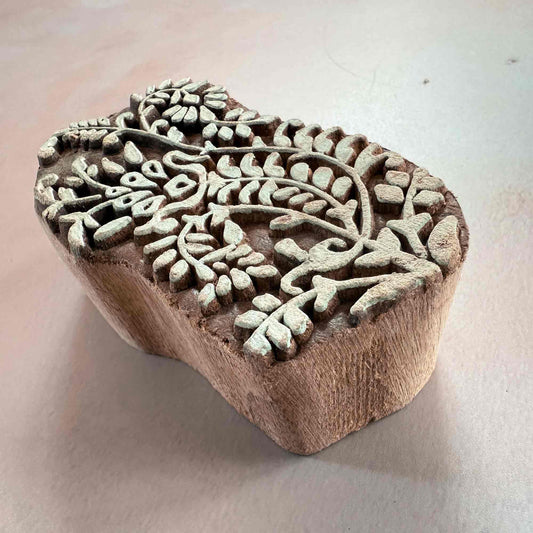 Wooden stamp with intricate floral design on a light background